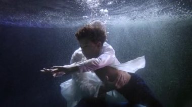 Baba küçük oğluna suya dalmayı ve yüzmeyi öğretiyor, baba ve çocuğu yüzüyor.