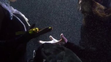 Ortaçağ kraliçesi şövalyeye kılıç veriyor. Suyun içinde yakın çekim, sualtı çekimi.