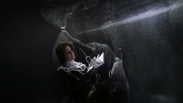 Χαριτωμένη γυναίκα βυθίζεται στο σκοτεινό βάθος του ποταμού με το βιβλίο, μυστηριώδες και αινιγματικό — Αρχείο Βίντεο