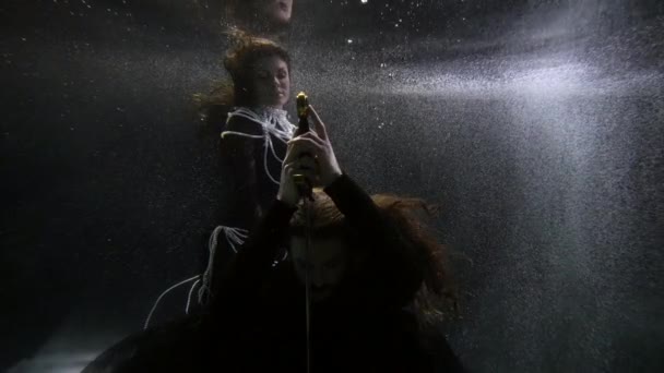 Medieval magic underwater, man with sword and mysterious lady with pearls necklace — Stockvideo