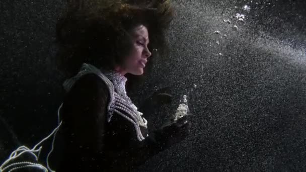 Mystisk kvinna flyter under vatten och leker med pärlor, undervattens drottning eller häxa — Stockvideo