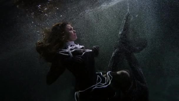 魔法と夢のコンセプトエレガントなブルネットの女性は水中で浮いている — ストック動画