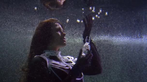 驚くべき水中のおとぎ話、ブルネットの女性は湖で泳ぐ魔法の真珠と遊んでいます — ストック動画