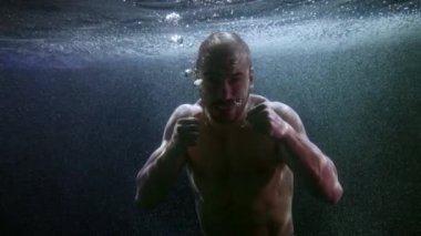 Öfkeli ve agresif bir adam sualtında yüzüyor, saldırıdan önce savaşçı portresi.