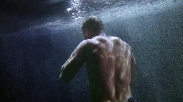 Force l'homme se bat seul sous l'eau, dos masculin musclé, tir subaquatique — Video
