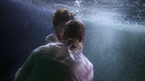 Father and son are swimming underwater, slow motion shot, happy embrace of little boy and his dad — Stockvideo