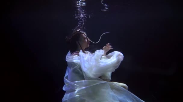 Sensual joven mujer está buceando en la profundidad oscura del río o lago, cámara lenta bajo el agua disparo — Vídeo de stock