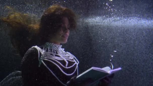 Elegant woman is reading book, underwater shot, dream and fantasy, mystery fairytale — Stock Video