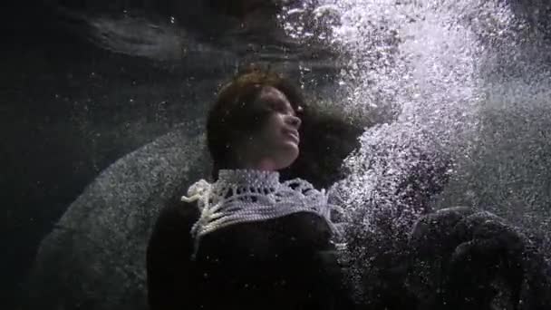 Elegante dama con perla vestido decorado es flotante bajo el agua y beber de copa de vino — Vídeo de stock