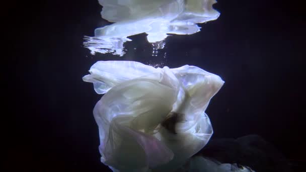 Plan sous-marin romantique au ralenti, femme flottante dans l'obscurité profonde — Video