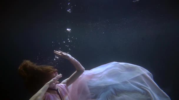 Solitário sonhando mulher está nadando em profundidade de mar, lago ou piscina à noite, tiro subaquático — Vídeo de Stock