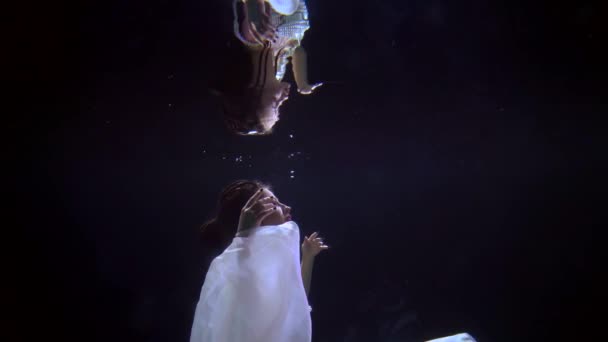 Hermosa sirena está flotando en profundidad y jugando con su reflejo, tiro en cámara lenta bajo el agua — Vídeo de stock
