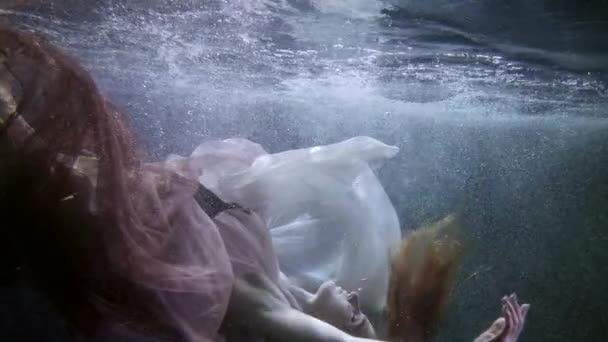 Beautiful woman is plunging inside water and floating, underwater shot in pool or lake — Vídeo de Stock