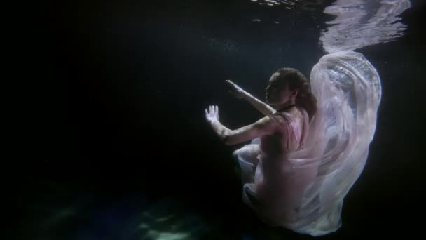 Mujer seductora está flotando en la profundidad de la piscina oscura, vestido romántico fluyendo de seda — Vídeo de stock