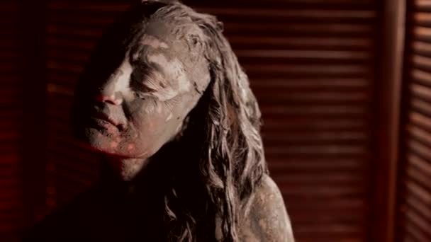 Art performance of strange young woman, lady in mud is posing emotionally, portrait shot — стоковое видео