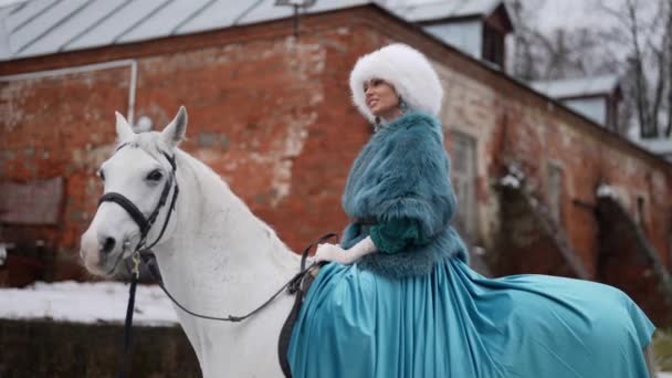 Piękna szlachcianka na koniu w starym stajni zimą, romantyczny strzał z dawnych czasów — Wideo stockowe