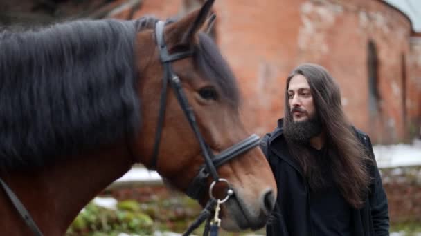 Enigmatic man with horse in yard of ancient castle, historical shot — Video Stock