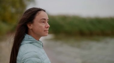 Portrait of a beautiful adult Caucasian woman. A pretty middle-aged lady with an attractive appearance looks away while standing on the street.