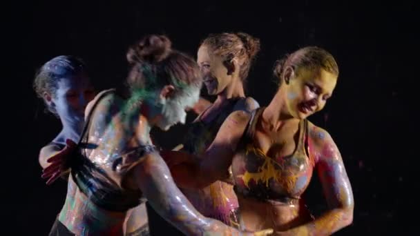 Веселі жінки танцюють і грають з фарбами, шкіра покрита різнокольоровими барвниками — стокове відео
