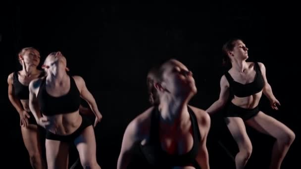 Young sexy ladies are dancing sensual modern dance in darkness, slow motion shot — Stockvideo