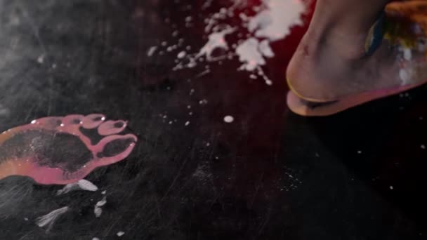 Barefooted woman is walking and leaving footprints on black floor, closeup view, feet in paints — Vídeo de Stock