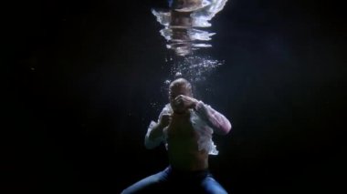 male figure underwater, boxer is fighting, waving fists