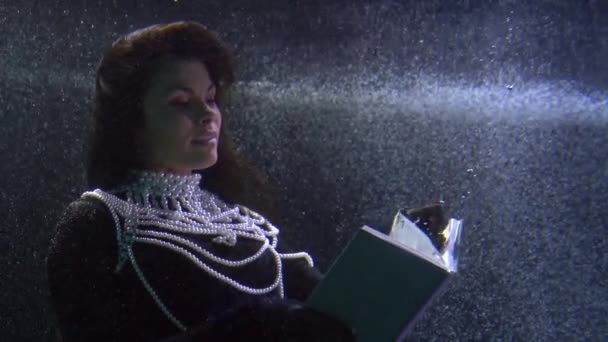中世の王女は本を読んでいる、素晴らしい水中ショット、魔法と夢の概念 — ストック動画