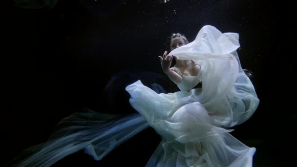 Magic mermaid is floating in darkness and depth of ocean, slow motion underwater shot — стоковое видео