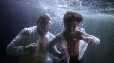 little boy and his father are swimming inside pool and training punches by hands