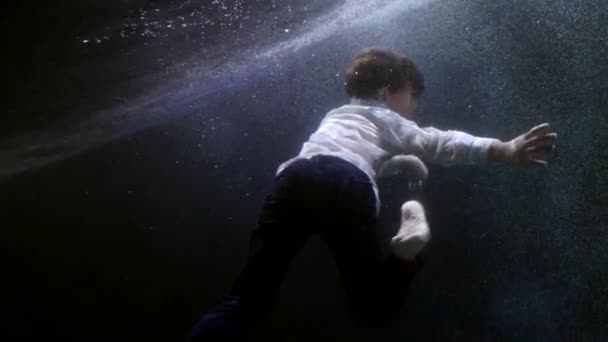 Child is sinking in river, underwater shot, little boy is swimming inside depth, holding breath — 비디오