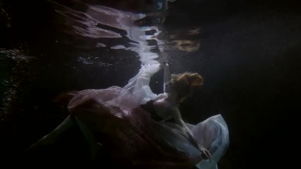 Romántico y dramático tiro bajo el agua con mujer elegante buceo en profundidad de mar o piscina — Vídeos de Stock