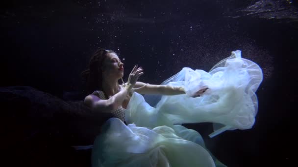 オーシャニックプリンセス白いドレスを着た美しい若い女性と一緒に水中のスローモーションショット — ストック動画