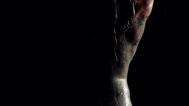 Woman is showering off clay and mud from her sexy body, sensual shot in darkness — Wideo stockowe