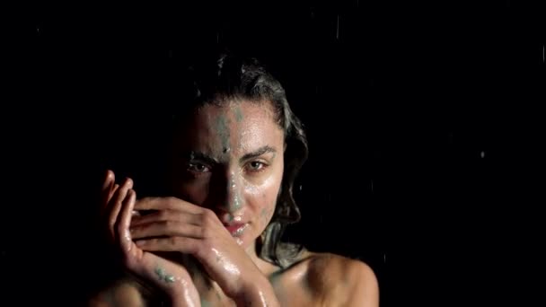 Stunning woman covering by mud is standing in shower, washing down clay under water flow — Αρχείο Βίντεο