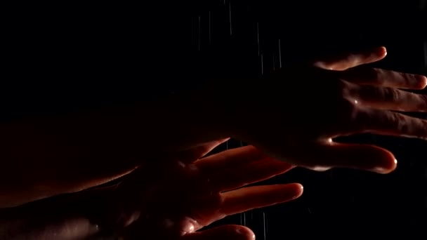 Woman in rain in night, closeup of sensual female hands in black background — Video