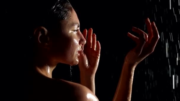 Woman in water flows in darkness sensual and romantic shot, portrait of woman in shower or in rain — Stockvideo
