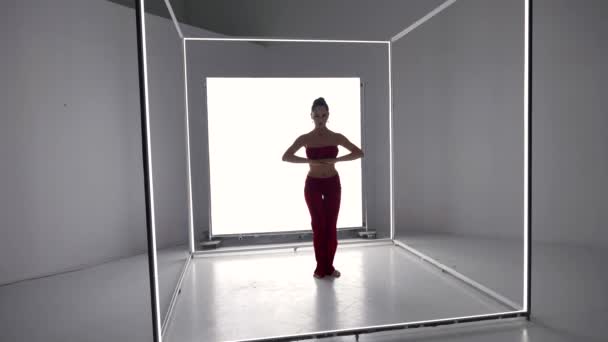 Sexy woman is dancing original modern dance style in room with white neon light cube — Αρχείο Βίντεο