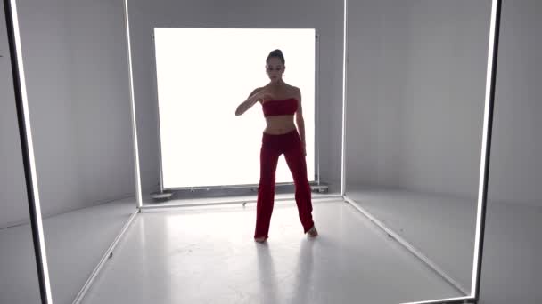 Modern dance of sexy young woman, brunette lady in red suit is dancing alone in room — ストック動画