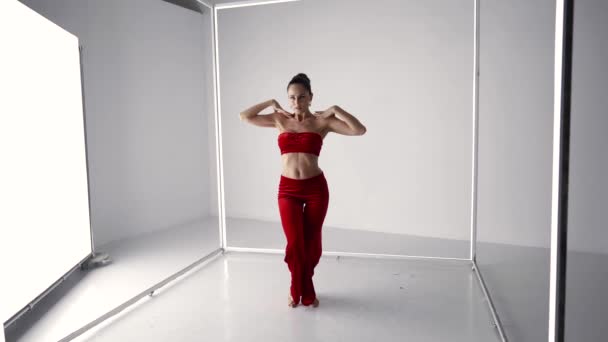 Passionate dancing woman in red suit, sexy lady is rehearsing dance in modern studio — Video