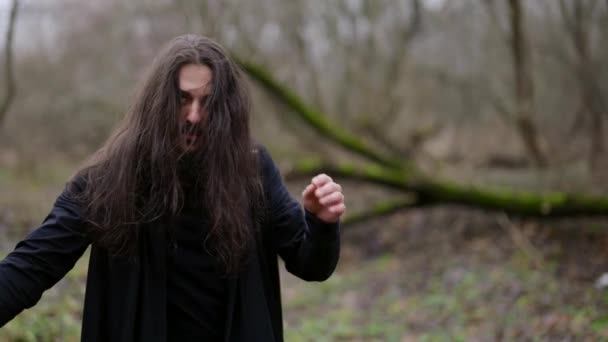 森の中で剣を持つ神秘的な長髪の男魔術師や戦闘機 — ストック動画
