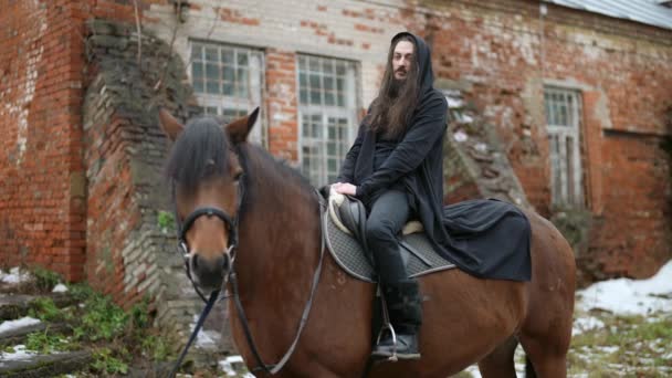 mysterious rider on horseback, enigmatic long-haired man with black hood