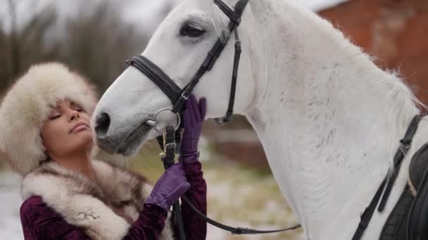 Charming beautiful woman is kissing white horse in yard of estate, historical scene — Video