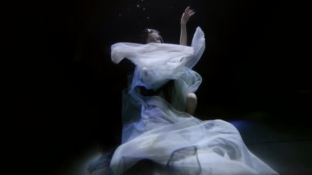 Amazing beautiful woman in white dress is dancing on bottom of magic sea or ocean — Video Stock