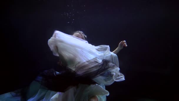 Mysterious young woman is sinking in dark depth of sea, romantic and sensual slow motion shot — Stock videók