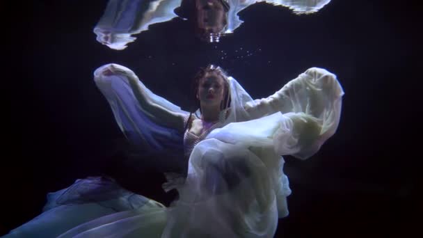 Mysterious female figure underwater, slow motion shot with enigmatic beautiful woman — Video