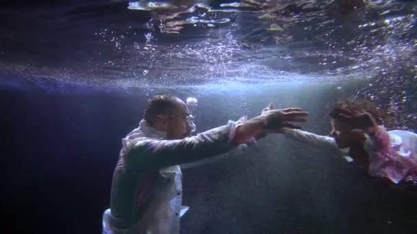 Adult man and his little son are swimming together inside water of pool, slow motion shot — Wideo stockowe