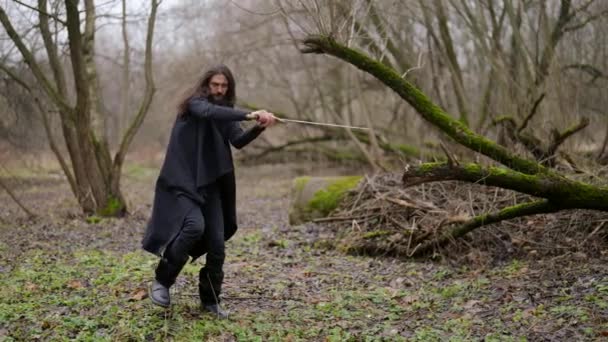 Középkori harcos karddal az erdőben, fekete mágus harcol láthatatlan ellenséggel — Stock videók