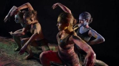 female dancing group is rehearsing dance with paints, four young women are dancing in darkness