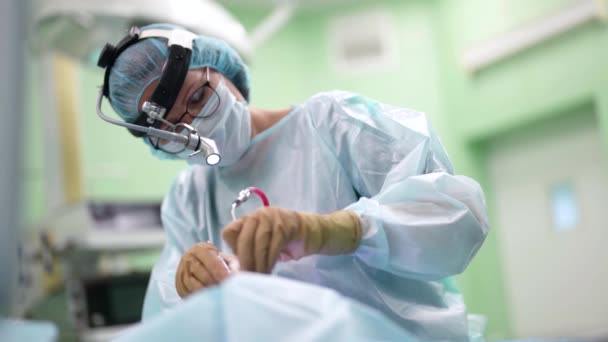 Квалифицированный врач проводит эндоскопическую операцию в отоларингологической клинике — стоковое видео