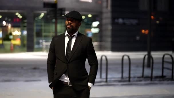 Hombre africano guapo y elegante está caminando solo en la ciudad en invierno por la noche — Vídeo de stock
